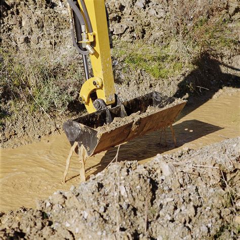 using a mini excavator for cleaning out a ditch|how to clean a ditch.